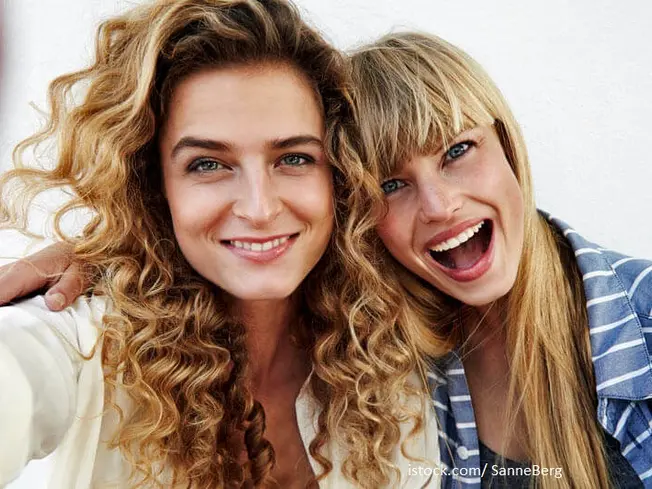 Zahnversicherung sinnvoll? Zwei Freundinnen mit strahlendem Lächeln machen ein Selfie.