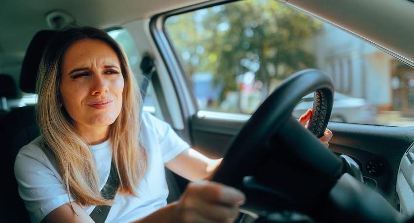 Bild einer Frau in einem Auto, die ihre Augen zusammenpresst, um besser zu sehen.