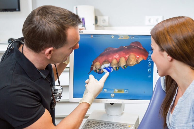 Zahnarzt berät einen Patienten über die CEREC-Zahntechnik